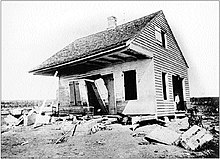 Black and white photograph of a damaged home