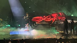 Dua Lipa performing in a white, glittery bodysuit in front of a giant inflatable lobster