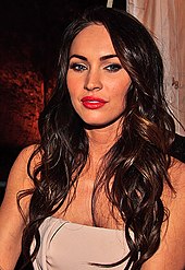 A shot of Megan Fox from the chest up, with dark brown hair.