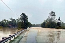 Tropical Storm Helene damage across North Carolina on Sept.. 27, 2024 showing flooded road next to swollen river