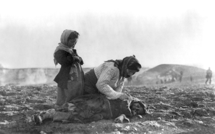 Armenian woman kneeling beside a dead child near Aleppo in during the Armenian Genocide. This was MILHIST's 300th featured picture. (created by American Committee for Relief in the Near East, restored by MjolnirPants)