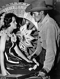 Lucas McCain looking at woman sitting in front of roulette wheel