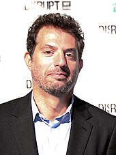 Guy Oseary smiling towards the camera.