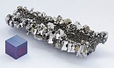 Niobium crystals and a 1 cm3 anodized niobium cube for comparison