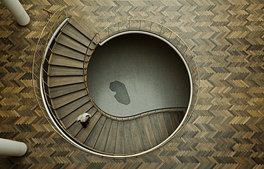 Una escalera en el Ayuntamiento de Aarhus, Dinamarca. La piedra angular gris oscuro con forma de riñón que se ve en la parte inferior del hueco de la escalera contiene las tres piedras fundamentales del edificio y se usó como punto de referencia para el ajuste de altura durante todo el período de construcción.