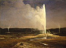 Geysers erupting vertically. Sunlight illuminating the one in the foreground and the breeze is blowing the steam and spray to the left.