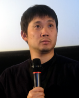A photograph of Ryusuke Hamaguchi speaking at the 2018 Hong Kong Asian Film Festival