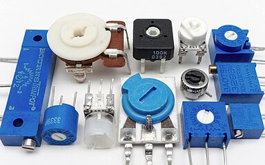 An assortment of small through-hole potentiometers designed for mounting on printed circuit boards.