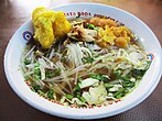 Soto, a traditional soup made with rich broth, tender meat, and fresh vegetables, often served with rice and various toppings.