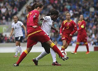 Eniola Aluko of England (in white) and Jovana Mrkić (in red) of Montenegro, 2014