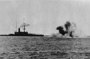 Photo of a ship sinking by the bow, with another ship close by