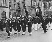 Black and white photo of old men in a parade