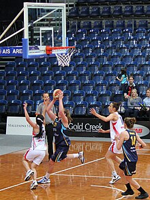 An image of players on one side of the basketball court with a throw about to be made