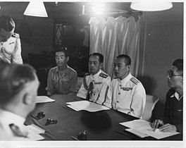 Rear Admiral Jisaku Uozomi (second from right) discussing the surrender of Penang with Vice Admiral Harold Walker aboard HMS Nelson