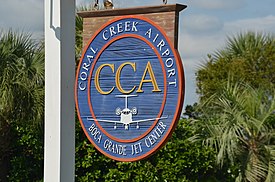 Wooden sign at the main entrance of Coral Creek Airport