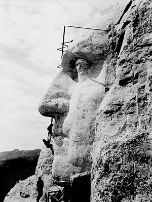 פועלים על הר ראשמור בעת פיסול האנדרטה שעליו, ניצבים על דמות פניו של ג'ורג' וושינגטון, בשנת 1932.
