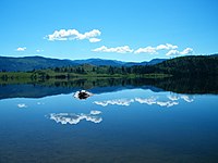 Blue lake with far shore visible and a clear sky above the lake