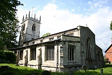 A single storey church building with a tower on the left