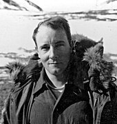 Photo en noir et blanc d'un homme d'une trentaine d'années avec une veste en fourrure.