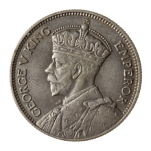 A crowned portrait of George V in royal dress, with the encircling text GEORGE V KING to the left, and EMPEROR to the right.