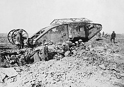 Early First World War tank, with soldiers in a trench next to it