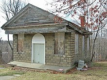 Color photograph of the cemetery chapel seen in the film, now with all windows boarded over.