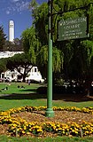 A sign in the park, with Coit Tower in the background
