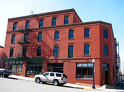 Photograph of a four-story brick building on a city street corner