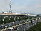 即將進入台中站的南下列車，前方道路為中山高速公路