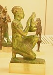 Statuette of a kneeling man, maybe a priest, offering a small Maat figure. Bronze with agemina. Third Intermediate Period/Late Period