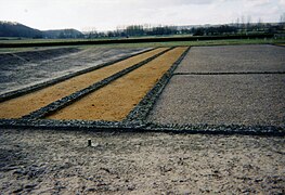 Photographie en couleurs de la base de longs murs parallèles.