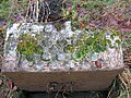 A highly ornate planter or trough near the walled garden