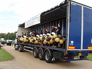 A semi-trailer truck with a curtain sider trailer being used as a stage for a band