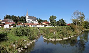 Taufkirchen mit der Pram im Vordergrund und der Pfarrkirche im Hintergrund