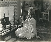 Black-and-white photograph of woman gazing into hand mirror