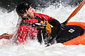 A kayaker surfaces at the end of a roll on whitewater