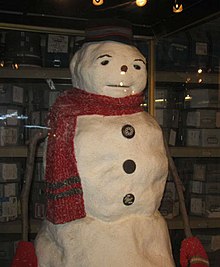 Un bonhomme de neige factice utilisé pendant le tournage du film. Il est fait de 3 boules, porte un bob noir, une écharpe rouge, des bras en bâton avec des moufles et des boutons de manteau sur le torse.