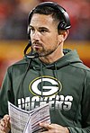 Photo of LaFleur during a game wearing a Packers sweatshirt and holding the play calling sheet