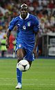 Full-body colour photograph of Mario Balotelli playing football during a match in 2012