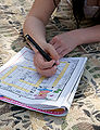 Person solving a Finnish crossword puzzle