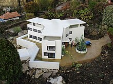 A white Modernist building with three wings