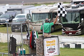 The flagman displays the checkered flag in 2018