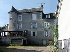 Photographie en couleurs d'un bâtiment portant, à un de ses angles, une tourelle cylindrique.