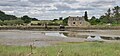 Le moulin de Berringue et sa digue vus depuis le sentier piétonnier longeant le chenal de Berringue à marée basse.