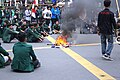 Students gather around a makeshift fire in the middle of an intersection near the North Sumatra DPRD