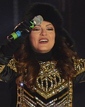 A picture of Andra during a concert, wearing fur winther clothing.