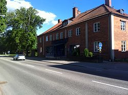 Röd tegelbyggnad, två våningar hög med valmat tak. Ett blått, inglasat burspråk används som entré. Ordet "Smålänningen" står med stora blå bokstäver ovanför entrén.