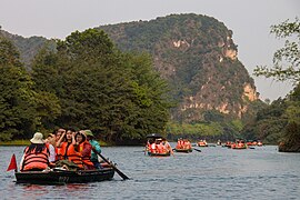 Nombreuses barques touristiques sur un plan d'eau.