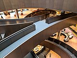 Spiral bronze coloured ramps connecting floors in an office building, viewed from above