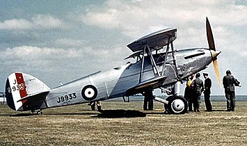 Photographie d'un avion biplan au sol.